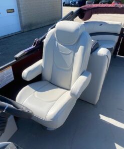 Interior view looking toward the stern of a Starcraft pontoon boat, featuring two light gray upholstered captain's chairs, a steering console, and additional rear lounge seating under a maroon bimini top.